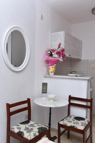 a kitchen with two chairs and a table with a mirror at Klaris Guest house in Budva