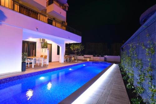 a swimming pool in a house at night at Klaris Guest house in Budva
