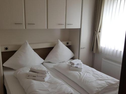 ヴェスターラントにあるSylter-Besserburg-App-15のベッド(白い枕、タオル付)