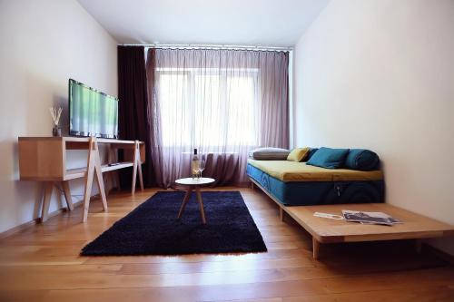 Habitación con cama, mesa y TV. en Living In Aparthotel, en Oradea