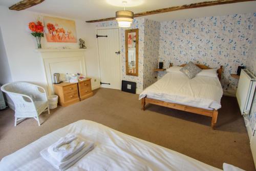 a large bedroom with a bed and a chair at The Penrhos Arms in Cemmaes