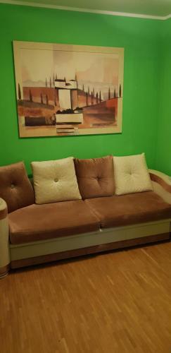 a brown couch in a room with a green wall at Haus Enteresan in Cologne