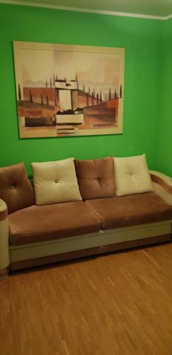 ein braunes Sofa in einem Zimmer mit grüner Wand in der Unterkunft Haus Enteresan in Köln