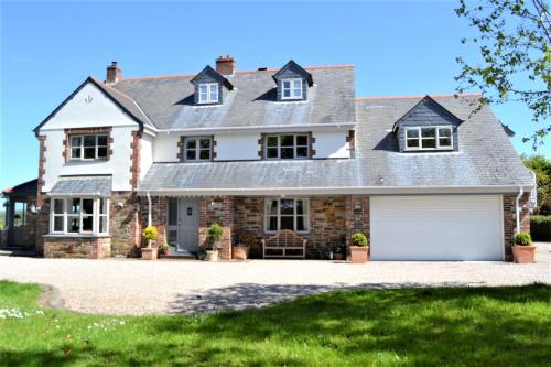 uma casa de tijolos com garagem em Brookfields em Wadebridge