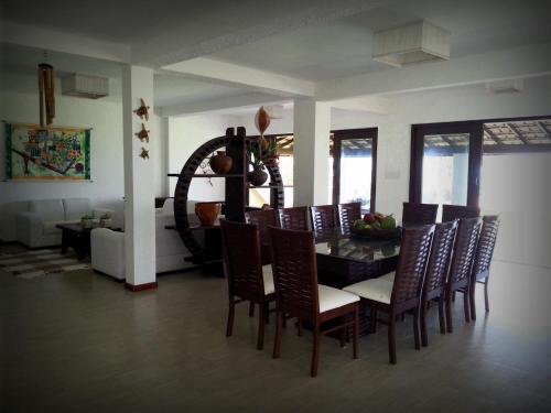 a dining room with a table and chairs at Casa de Gente Feliz Guarajuba - 6 suítes Pé na Areia in Guarajuba