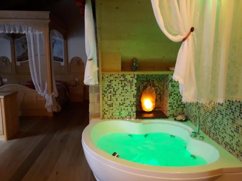 uma banheira com lareira num quarto em B&B Al Cedro em Sporminore
