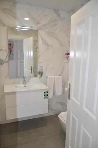 uma casa de banho branca com um lavatório e um WC em Edificio Charles 301 em Funchal