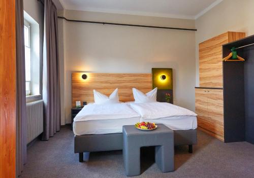 GüntersbergeにあるHarzHotel Güntersbergeのベッドとテーブルが備わるホテルルームです。