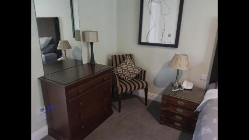 a bedroom with a dresser and a chair and a desk at Luxury 2Bedroom Lodge in Auchterarder