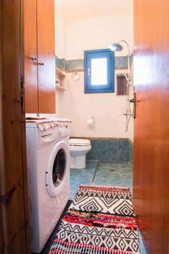 a bathroom with a washing machine and a toilet at Finiki Studios in Karpathos Town