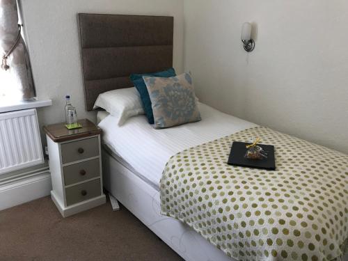 a small bedroom with a bed with a tray on it at The Cleveland in Torquay