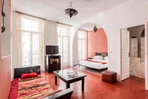 a bedroom with a bed and a table in a room at Le Ryad Boutique Hôtel in Marseille