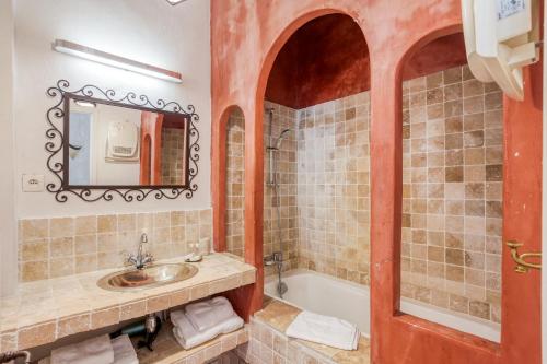 a bathroom with a sink and a tub and a mirror at Le Ryad Boutique Hôtel in Marseille