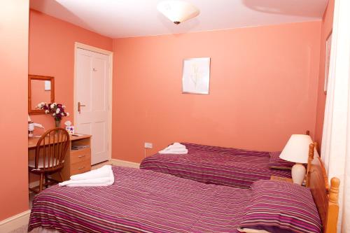 a bedroom with two beds next to a desk and a desk at Holbrook Bed and Breakfast in Shaftesbury