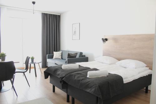 a bedroom with a large bed and a living room at Forenom Serviced Apartments Rovaniemi Valtakatu in Rovaniemi