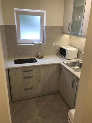 a small kitchen with a sink and a microwave at Milara Apartments in Budva
