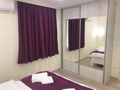 a bedroom with a mirror and a bed with red curtains at Milara Apartments in Budva