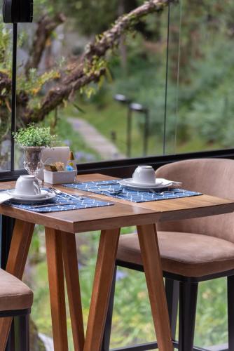 a wooden table with a plate of food on it at Villa Amistà Campos do Jordão in Campos do Jordão