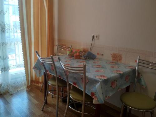 ジヴノモルスコエにあるApartment on Divnaia 1のダイニングルームテーブル(椅子、テーブルクロス付)