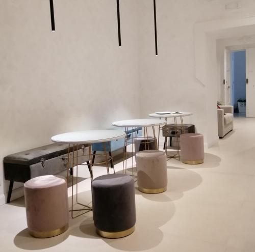 a group of tables and stools in a room with a piano at BARI 102 in Bari
