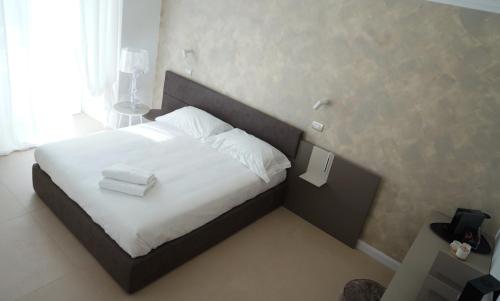a bedroom with a bed with white sheets and pillows at BARI 102 in Bari