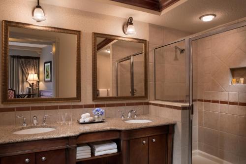 a bathroom with two sinks and two mirrors at Hammock Beach Golf Resort & Spa in Palm Coast