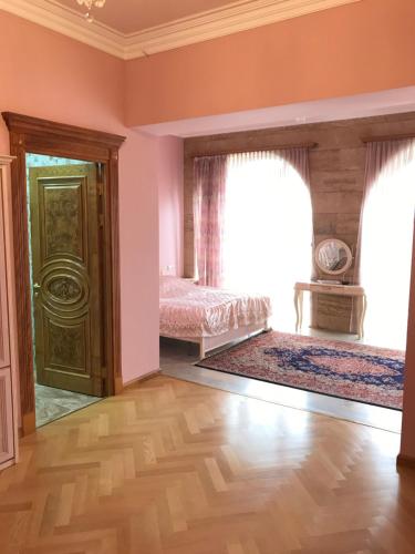 an empty room with a bed and two windows at A Royal Luxury Villa In Center With Two Swimming Pools, Sauna and Jacuzzi. in Yerevan