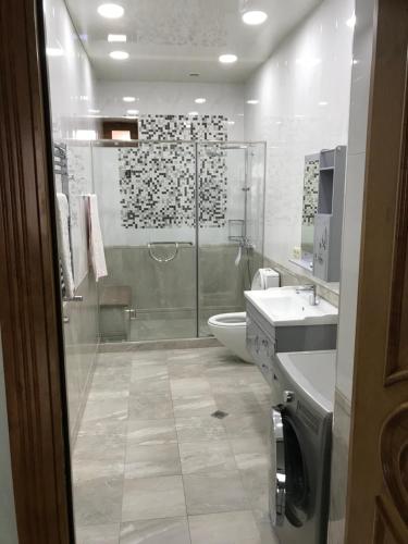 a bathroom with a shower and a toilet and a sink at A Royal Luxury Villa In Center With Two Swimming Pools, Sauna and Jacuzzi. in Yerevan