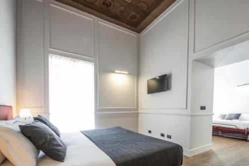 a bedroom with a bed and a tv on the wall at Gemini Suites Navona in Rome