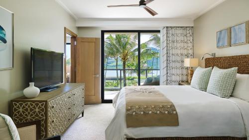 a bedroom with a large bed and a television at Timbers Kauai Ocean Club & Residences in Lihue