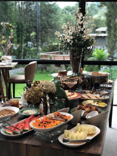 a table topped with plates of food on top at Villa Amistà Campos do Jordão in Campos do Jordão