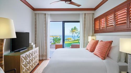 a hotel room with a bed and a television at Timbers Kauai Ocean Club & Residences in Lihue
