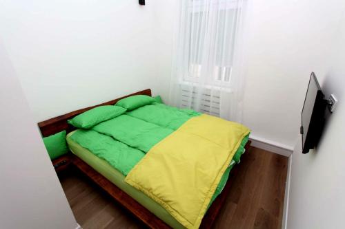 a small bedroom with a green and yellow bed at Old Town Luxury Apartments in Sarajevo