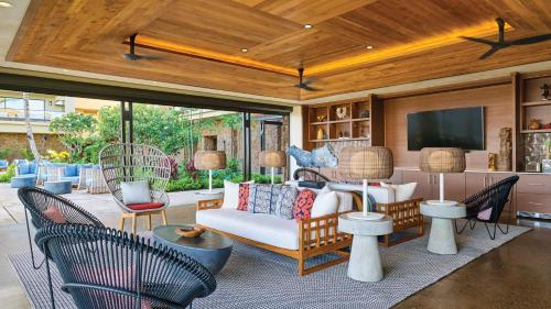 a living room with a couch and chairs and a tv at Timbers Kauai Ocean Club & Residences in Lihue