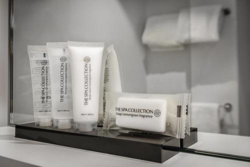 a shelf with two bottles of toothbrushes and towels at Hotel Bourgoensch Hof in Bruges