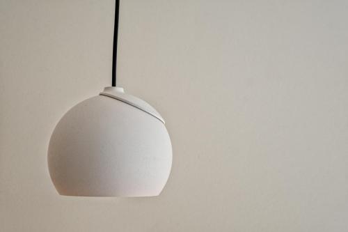 a white lamp hanging from a white wall at Hotel Bourgoensch Hof in Bruges