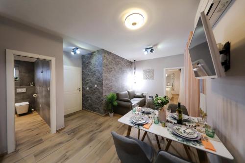 Aldo Apartments Center في زادار: غرفة معيشة مع طاولة طعام وغرفة معيشة