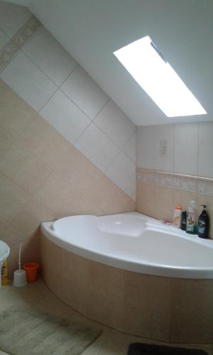a large bath tub in a bathroom with a skylight at Motelik Julia in Siedlce