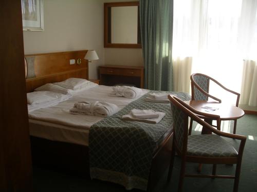 a hotel room with a bed with towels on it at Palast Wellness Appartement in Hévíz