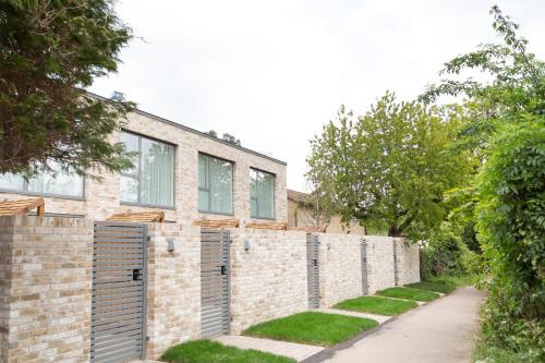 a brick house with a fence and a sidewalk at Citystay Living - Park House in Cambridge