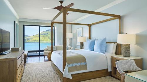 a bedroom with a bed and a large window at Timbers Kauai Ocean Club & Residences in Lihue