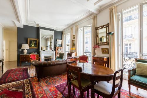 un salon avec une table et des chaises dans l'établissement Veeve - Moments From Monet, à Paris