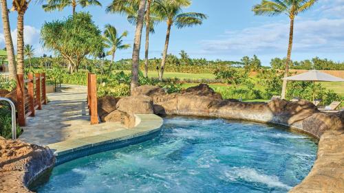 a pool in a resort with palm trees at Timbers Kauai Ocean Club & Residences in Lihue