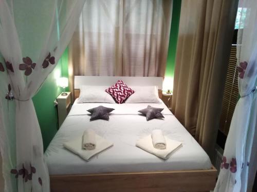 1 dormitorio con 1 cama con almohadas y toallas en Apartments Barocco en Golubac