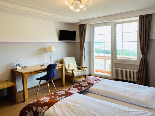 a hotel room with a bed and a desk and window at Gasthof zur Bündte in Jenins