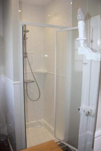 une douche avec une porte vitrée dans une salle de bain dans l'établissement Maison Cornic, à Crozon