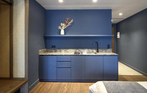 cocina azul con fregadero y pared azul en Roomore Apartments en Tesalónica