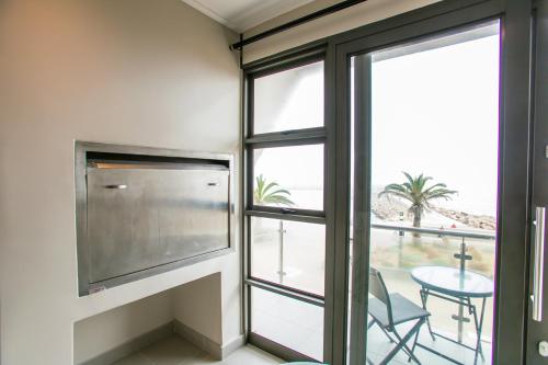 a room with a large window and a table with a chair at Platz am Meer no. 2 in Swakopmund