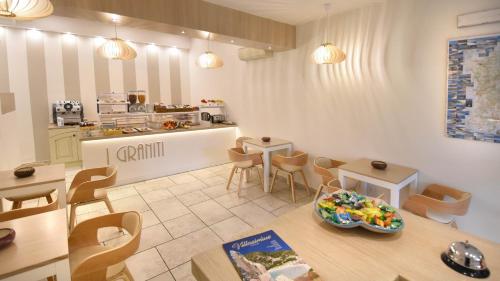 a room with a table and chairs and a kitchen at Hotel I Graniti in Villasimius