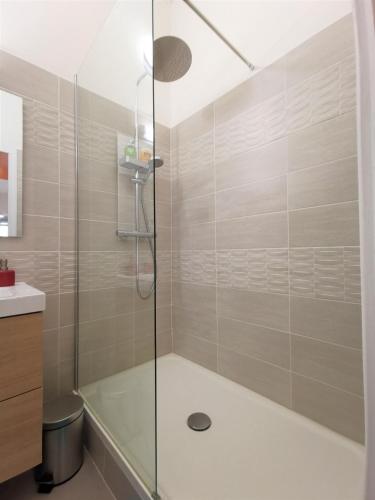 une douche avec une porte vitrée dans une salle de bain dans l'établissement BEAU T3 NEUF PROCHE VIEUX-PORT A LA PLACE CORDERIE, à Marseille